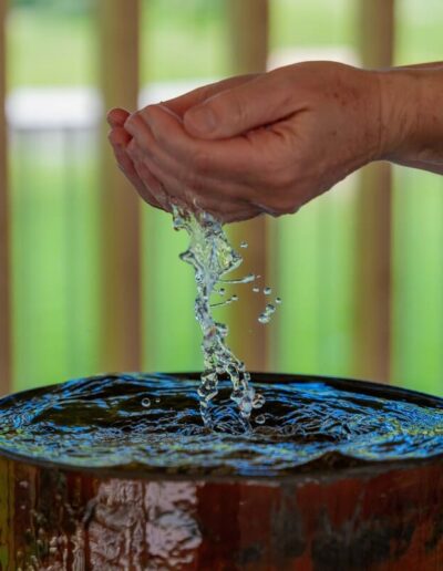 Wasser sprudelt aus den Händen der Wandlerin